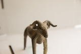 Detailed view of the vintage ram sculpture's face, highlighting its textured, aged patina.