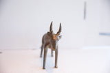 Head-on view of the vintage African antelope sculpture's expressive face and horns.
