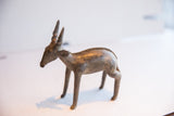 The elegant form and textured spine of the vintage African antelope sculpture.