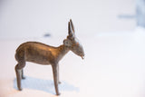 Profile view of the vintage antelope sculpture showcasing its handmade form and textured back.