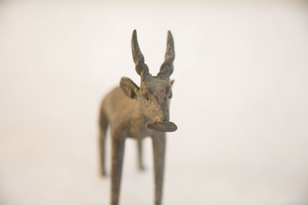 A direct frontal view of the vintage antelope sculpture's textured face.