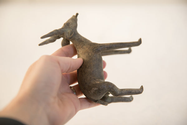 Underside view of the rustic African antelope sculpture held in a hand for scale.
