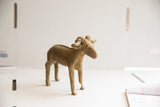 Side profile of the vintage ram sculpture highlighting its rustic, handmade texture and form.