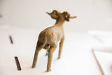 Rear view of the vintage ram sculpture highlighting its hand-etched spine.
