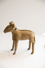 Full profile of a vintage African ram sculpture showing its standing pose and rustic texture.