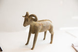 A profile view highlighting the textured spine and curved horns of the ram sculpture.