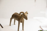 Angled view of the vintage ram sculpture's head, detailing the rustic texture and curved horns.