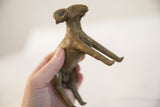 Vintage African ram sculpture held in hand, showing its profile and form from a low angle.