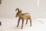 Three-quarter view of the vintage ram sculpture showing its handmade texture and curved horns.