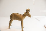 Handmade African ram sculpture seen in profile, showing its aged patina and stylized form.
