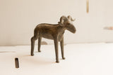 Profile view of the vintage African ram sculpture detailing its weathered, handmade finish.
