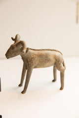 Profile of a vintage African ram sculpture highlighting its textured spine and weathered finish.