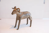 Aged patina and handmade texture on a vintage African ram sculpture shown in profile.