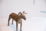Detailed view of the vintage ram sculpture's head, showing its textured curved horns.