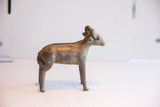 Vintage African ram sculpture's curled horns and textured braided detail along its back.