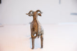 Back view of the vintage African ram sculpture highlighting its textured spine and tail.