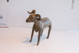 Angled view of the handmade vintage ram sculpture highlighting its textured, aged surface.