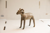 Left side profile of the vintage African ram sculpture, showing its rustic, handmade texture.