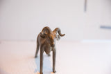 Vintage African ram sculpture viewed from the front, focusing on its face and textured horns.