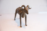 Handmade African ram sculpture shown from the front highlighting its prominent curved horns.