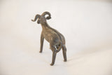 Textured back and curled horns of a handmade vintage African ram sculpture.