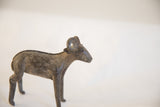Profile of the handmade African ram sculpture highlighting its curved horns and aged texture.