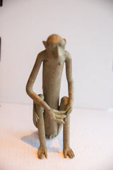 Frontal perspective of the slender, handmade African monkey figure in a seated pose.
