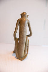 Rear view of the vintage African monkey sculpture, detailing its elongated back and form.