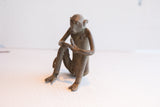 Side view of the handmade vintage African monkey sculpture highlighting its aged patina.