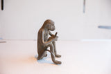 Side profile of the vintage African monkey sculpture detailing its sitting posture and form.