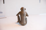 Back view of the vintage African monkey sculpture showing its slender form and aged texture.