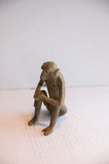 Side profile of the vintage African monkey sculpture in a seated posture.