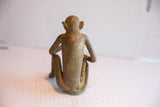 Rear view of the handmade vintage monkey sculpture, showing its aged patina and seated form.