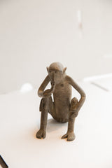 Frontal view of a stylized African monkey sculpture with a textured, rustic finish.