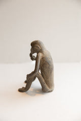 Angled rear view of the vintage monkey figurine showing its rustic, handmade surface texture.
