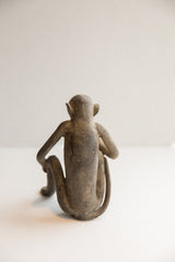 View from behind the vintage monkey figurine, showcasing its slender back and curved tail.