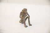 Right side view of the vintage African monkey figurine in a seated, thoughtful posture.