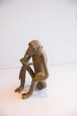 Side profile of the vintage monkey figurine showing its slender, seated posture.