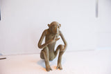 Vintage African monkey figurine in a thoughtful seated pose, showing aged patina.