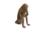 Vintage African sitting monkey figurine in a pensive pose with a rustic, handmade texture.