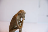 Profile view of the vintage sitting monkey showing its handmade textured surface.