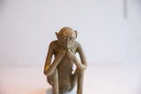 Eye-level view of the seated African monkey figurine in its classic thoughtful posture.