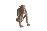 Vintage African sitting monkey figurine with a rustic, aged brown finish.