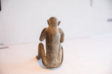 Rear view of the handmade monkey figurine showing its aged, textured patina.