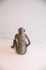 Back view of the vintage sitting monkey showing its slender form and aged texture.