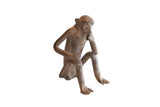 Vintage African monkey figurine seated in a pensive pose with a textured, aged patina.