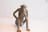 Pensive facial details and rustic texture of a vintage African monkey figurine.