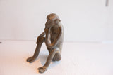 Side profile of the vintage African monkey figurine highlighting its thoughtful posture.