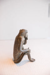 Side profile view of the vintage African monkey highlighting its handmade seated form.