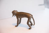Full side profile of the vintage African monkey figurine showing its form and textured spine.